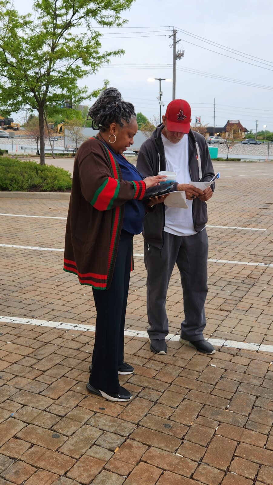 A street team member meeting with a person to get their opinion.