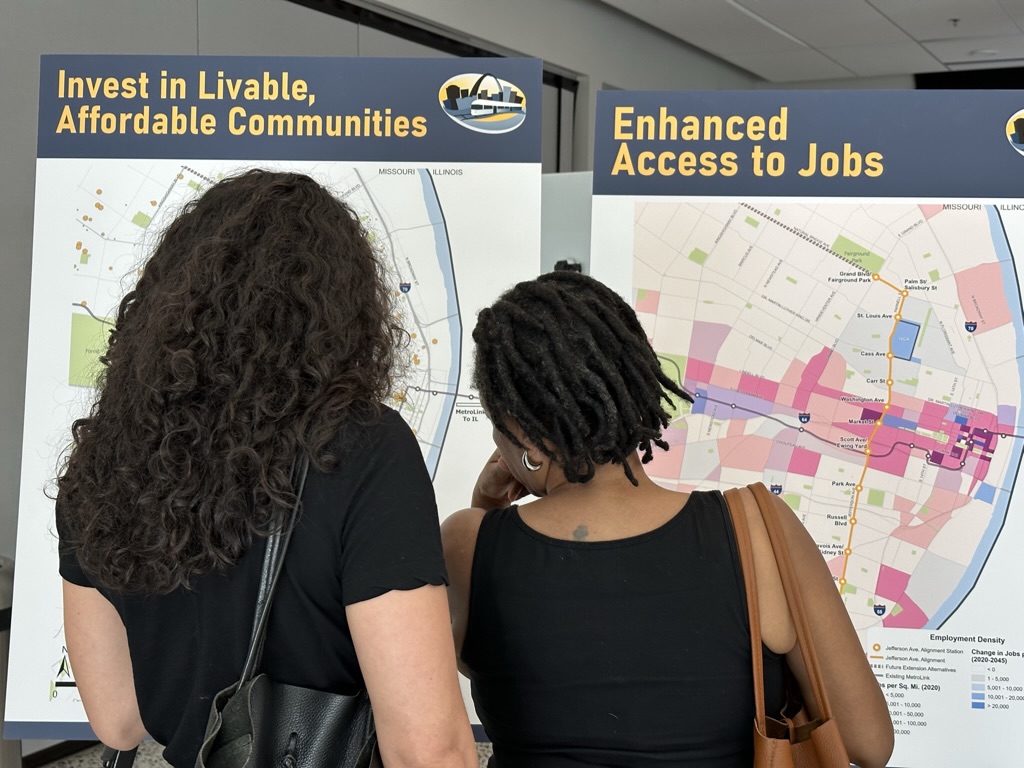 Photo of two women looking at public meeting boards.