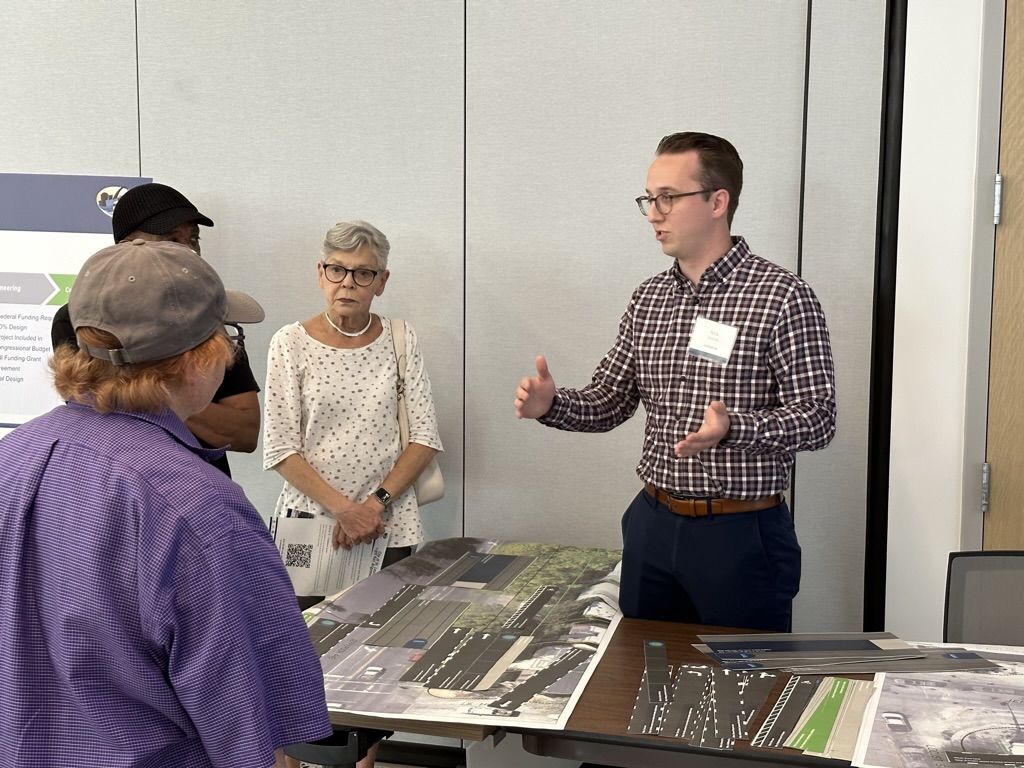 A team member talking with people about alignment at a public meeting.